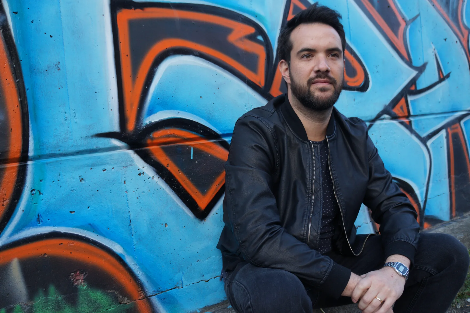Portrait of Spin in front of a graffiti wall